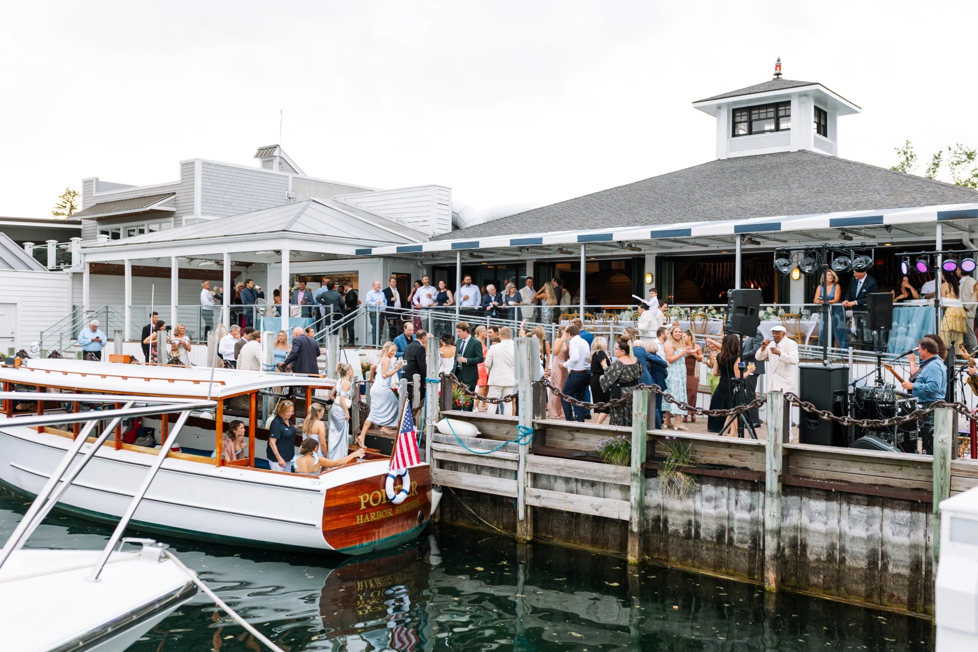 Guests gathered on the deck for a live music event with the Pointer boat tied up at the dock