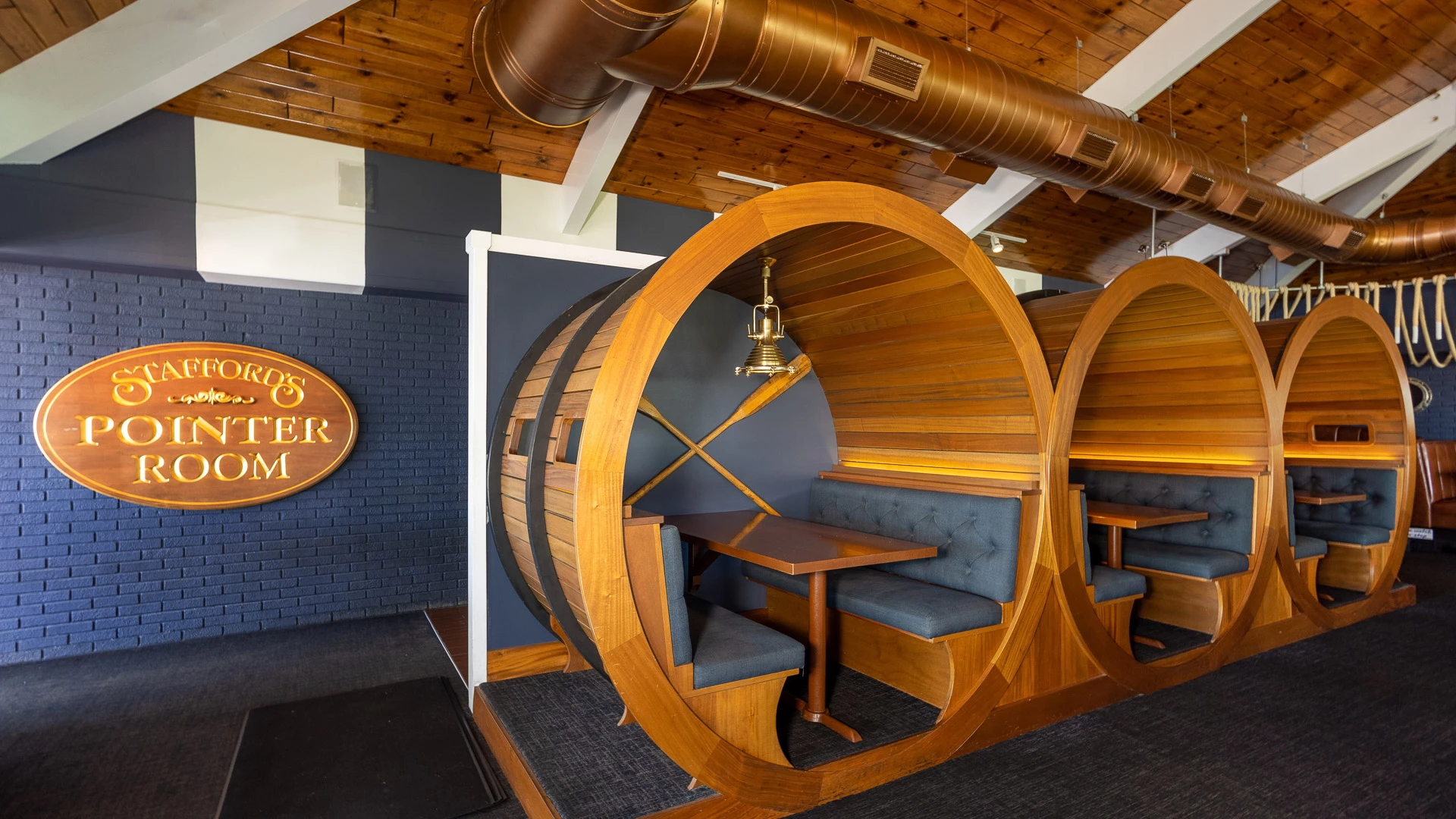 Barrel-shaped wooden booths beneath the Stafford's Pointer Room sign