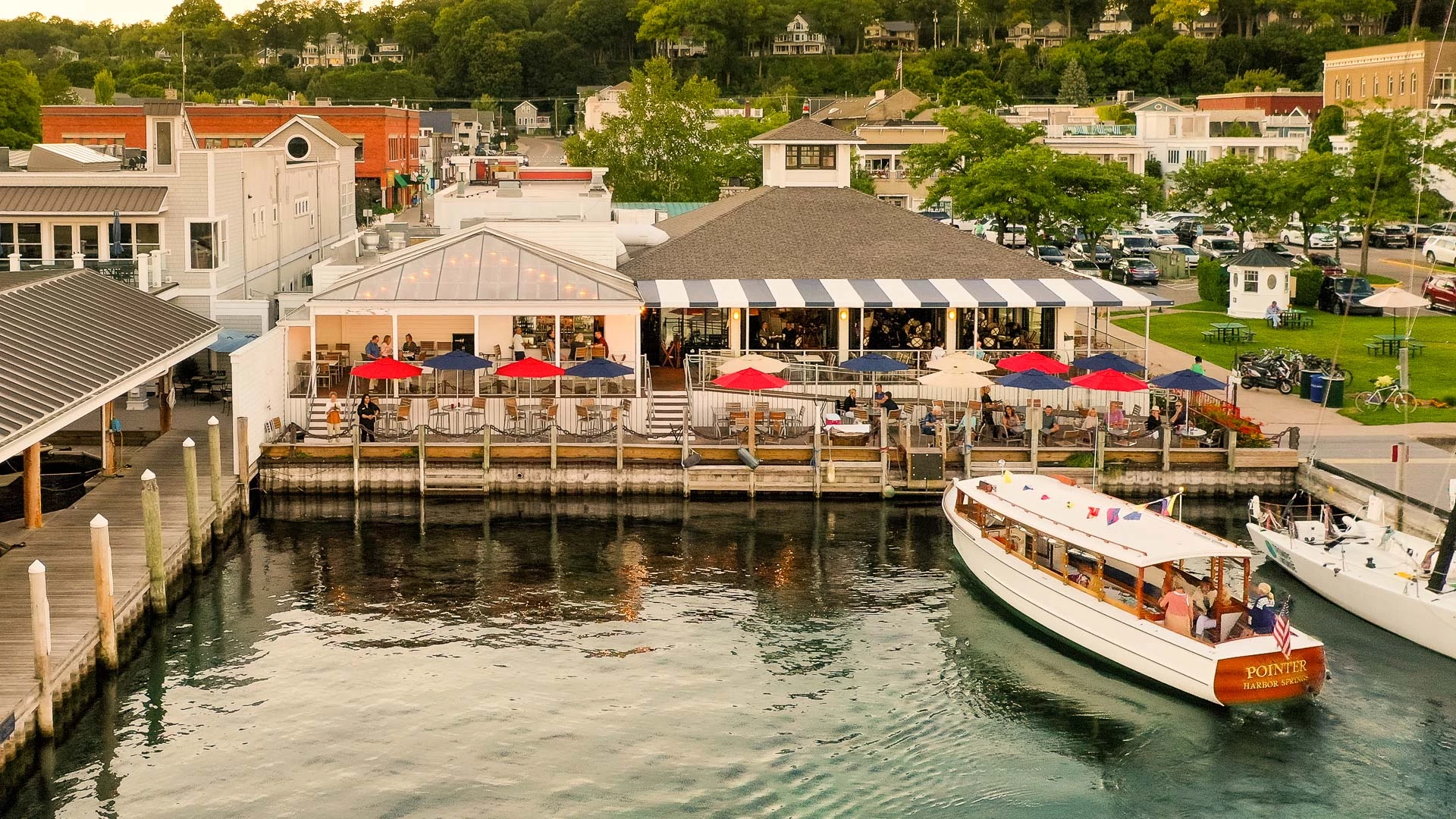 Aerial view of the restaurant's deck and umbrellas with the Pointer boat arriving in Harbor Springs