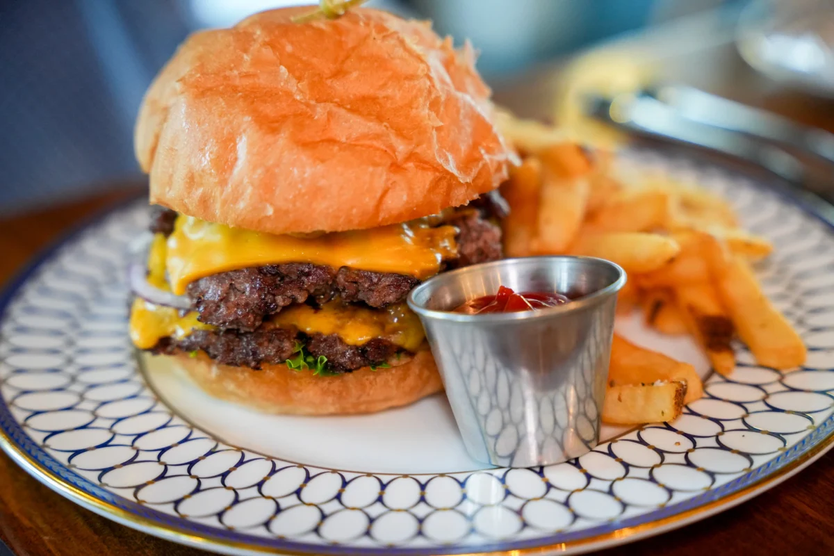 Double cheeseburger on a brioche bun with fries and ketchup