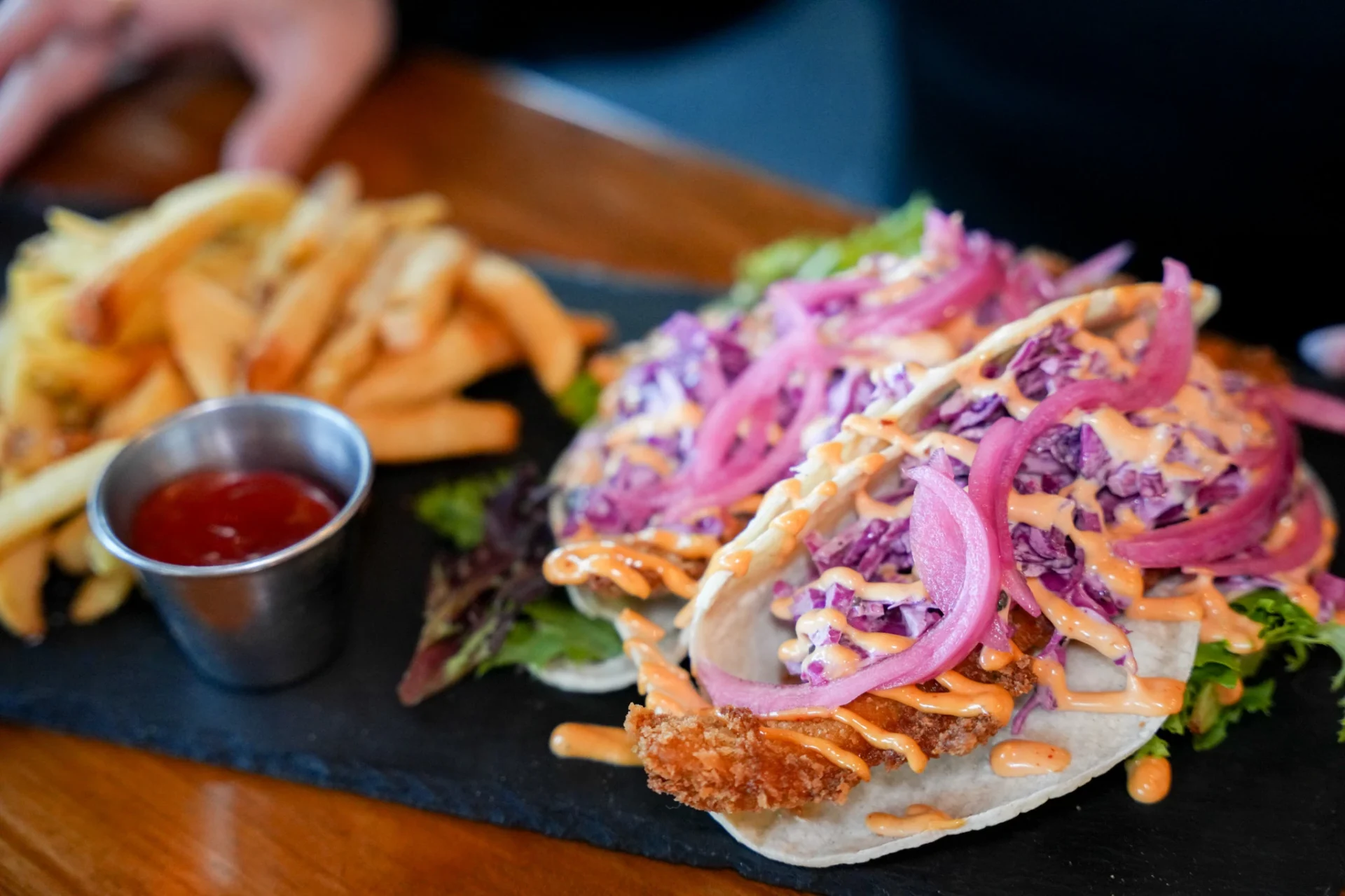 Crispy fish tacos with pickled red onion and slaw, served with fries