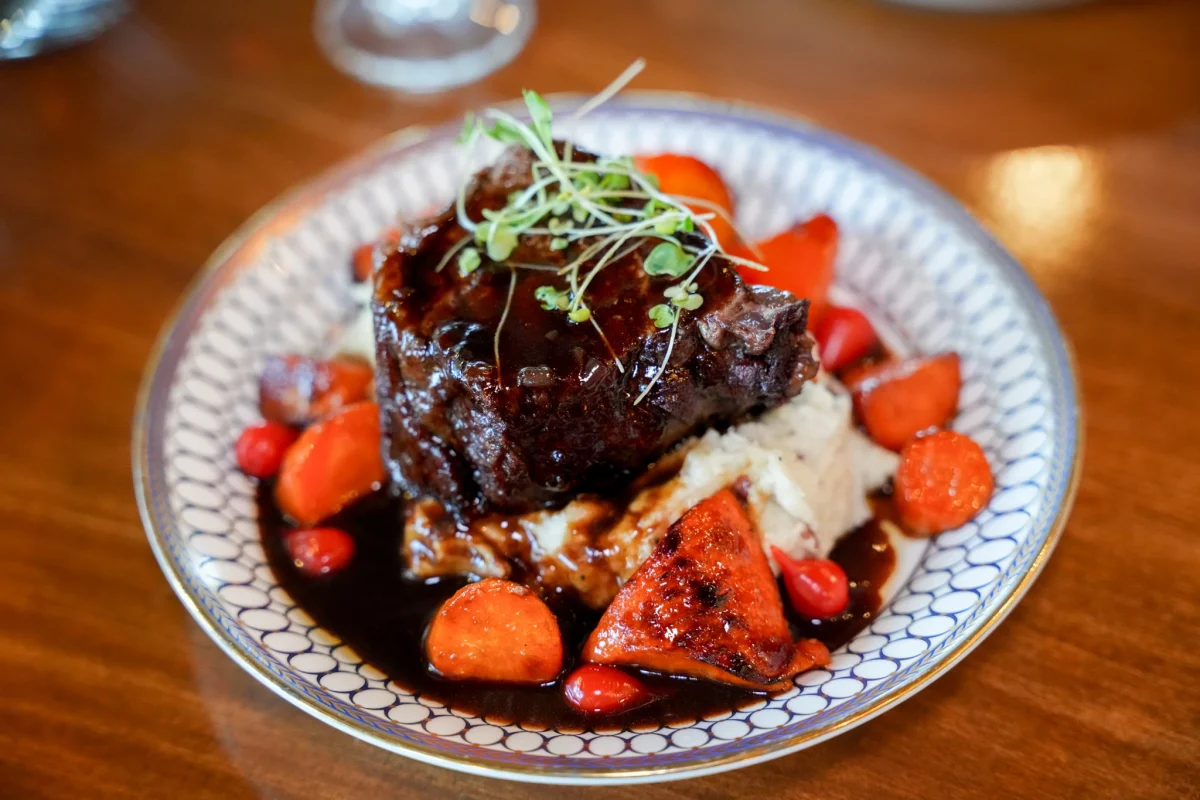 Braised short rib over mashed potatoes with glazed carrots in red wine sauce