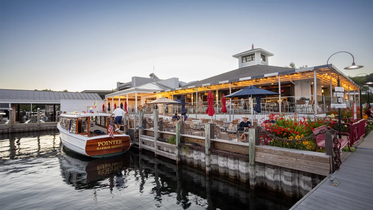 The Pointer boat docked alongside the restaurant's waterfront deck at dusk