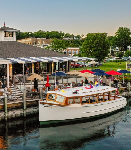 Umbrella-shaded tables on the lower deck beside the docked Pointer boat